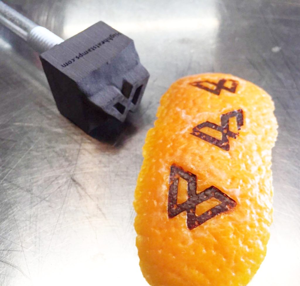 Custom branding iron logo imprint burned onto an orange peel